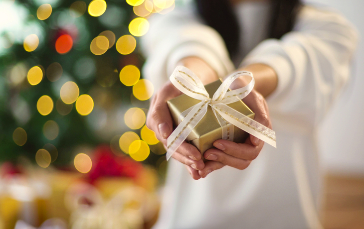 Nahaufnahme einer Frau, die eine Weihnachtsgeschenkbox hält